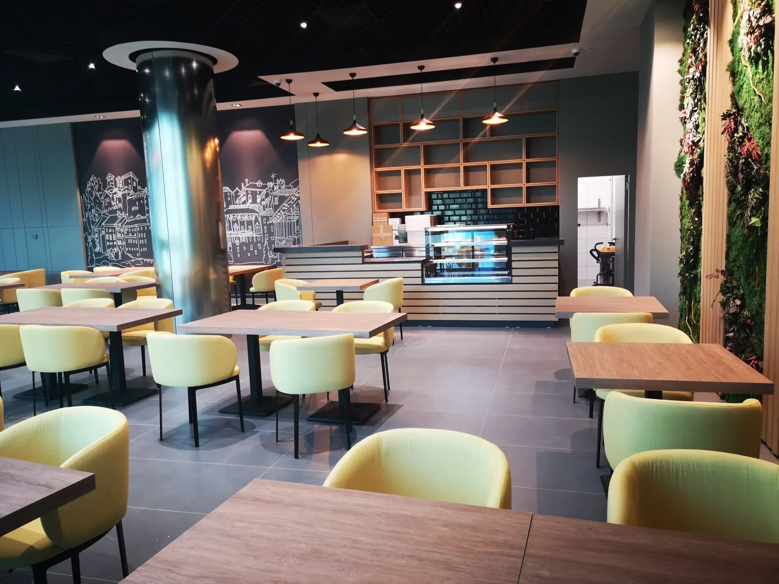 Confidence Group — Business Center Interior — Cafeteria seating arrangement with contemporary colorful furniture and ambient pendant luminaires